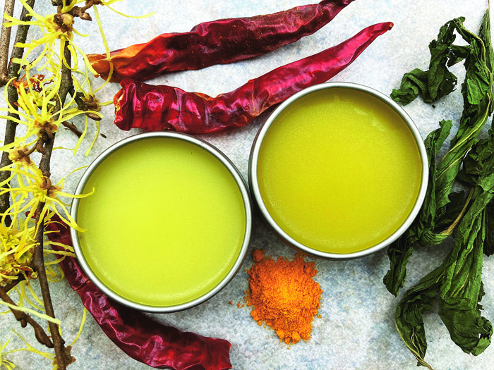 Herbal salve surrounded by cayenne pepper, nettles and witch hazel, Photo by Heather Cohen